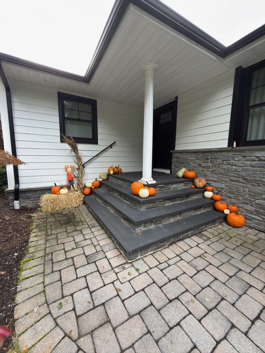 Pumpkin porch display on a gray stone porch in the Pascack Valley, NJ